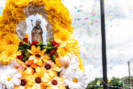 Image of Santo Domingo being carried on an altar adorned with flowers in Managua, Nicaragua