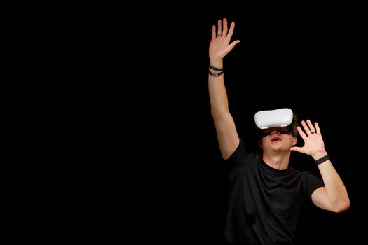 Young man wearing virtual reality VR glasses, goggles isolated on black background. Inside A Metaverse games and education concept.