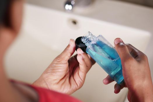 mouthwash liquid flowing into a cap , close up