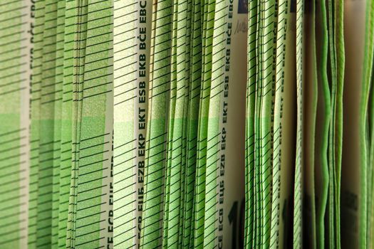 Close-up of a stack of paper bills, side view. Euro banknotes stacked on top of each other. Big pile of money