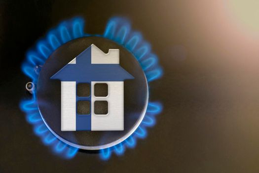 gas crisis. Rising utility costs in Finland. Energy crisis, export-import problems in Finland. The concept, gas burner and house model are colored in the colors of the flag
