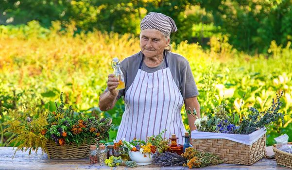 Grandmother makes tinctures from medicinal herbs. Selective focus. People.