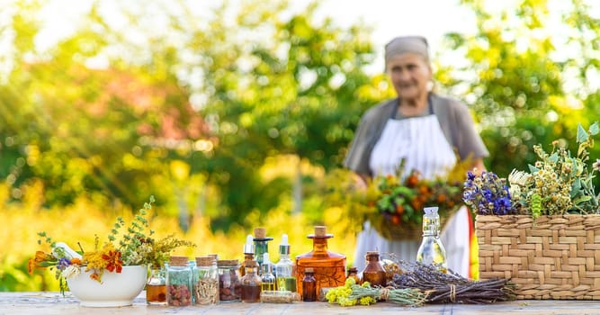 Grandmother makes tinctures from medicinal herbs. Selective focus. People.