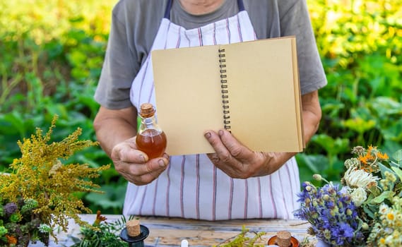 Grandmother makes tinctures from medicinal herbs. Selective focus. People.