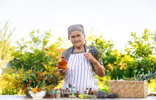 Grandmother makes tinctures from medicinal herbs. Selective focus. People.