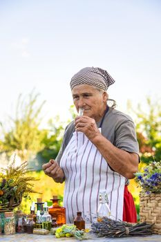 Grandmother makes tinctures from medicinal herbs. Selective focus. People.