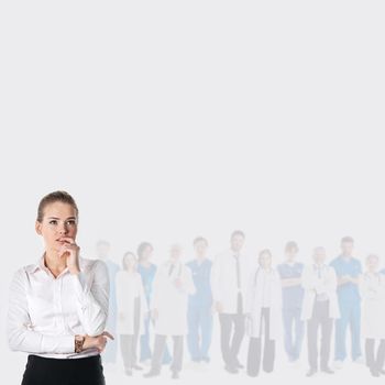 Young woman choosing doctor medical care concept, team of doctors on background, gray background with copy space for text