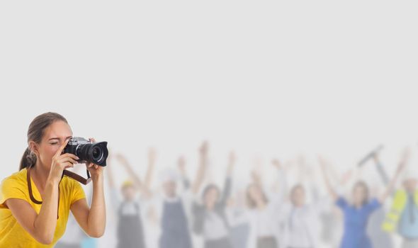 Young photographer girl with camera over many customers people over gray background with copy space