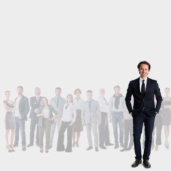 Businessman standing full length in front of his colleagues team over gray background