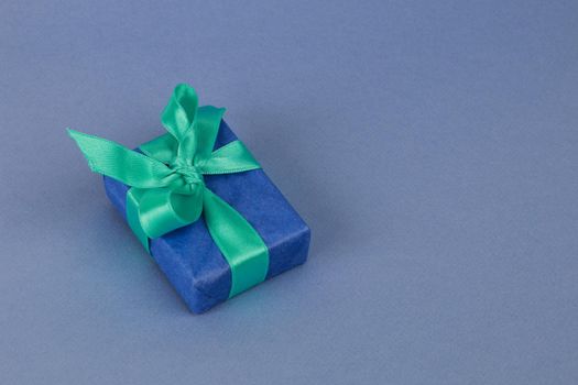 Blue gift box on a paper background, free space, space for text.