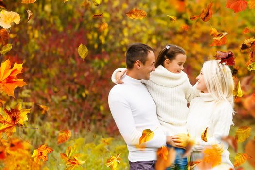 family, childhood, season and people concept - happy family playing with autumn leaves in park. High quality photo