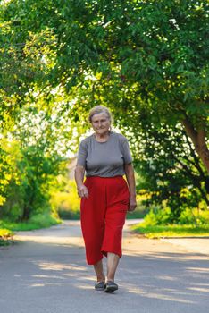 grandma is walking down the road. Selective focus. Nature.