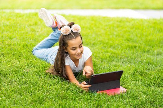 education, free time, technology and internet concept - little student girl with tablet pc.