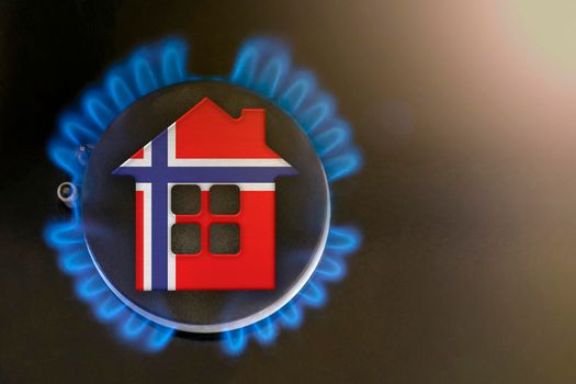 gas crisis. Rising utility costs in Norway. Energy crisis, export-import problems in Norway. The concept, gas burner and house model are colored in the colors of the flag
