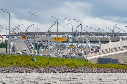 Russia, St. Petersburg, 29 July 2022: Exit from Vasilyevsky Island to the high-speed bypass road, road signs over the toll road, automobile traffic on the embankment, western high-speed diameter. High quality photo