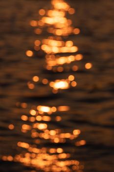 Awe beautiful vibrant orange shallow sun path of round highlights spot particles on sea out of focus area. Summer travel scene