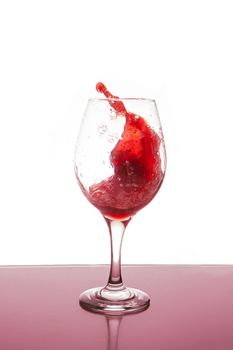 A Glass of red wine splashing isolated.