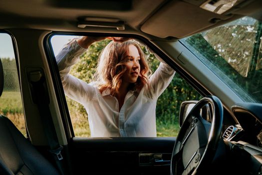 Woman in car travel relaxing and enjoying peace and silence of beautiful nature landscape. Woman in the car window. Trips and travels out of town