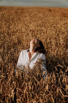 Summer nature, summer holidays, vacation and people concept. Close up of happy young woman in the ears of a rye field