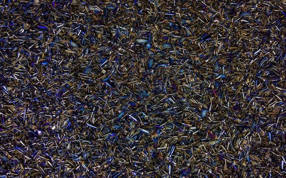 Colored black Steel Chips flat background with natural thermal surface hardening discoloration.
