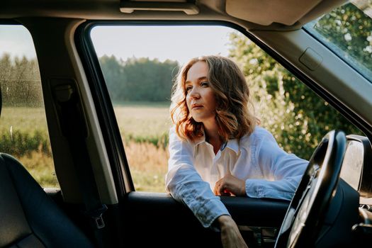 Woman in car travel relaxing and enjoying peace and silence of beautiful nature landscape. Woman in the car window. Trips and travels out of town