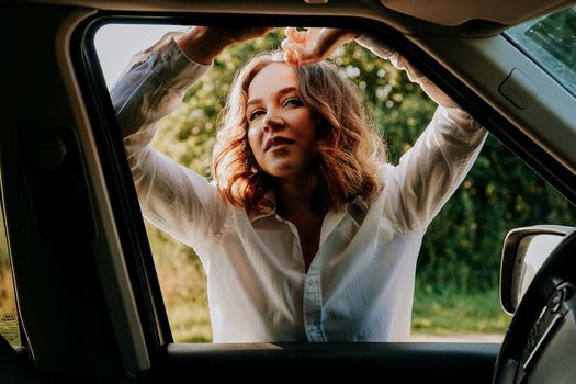 Woman in car travel relaxing and enjoying peace and silence of beautiful nature landscape. Woman in the car window. Trips and travels out of town