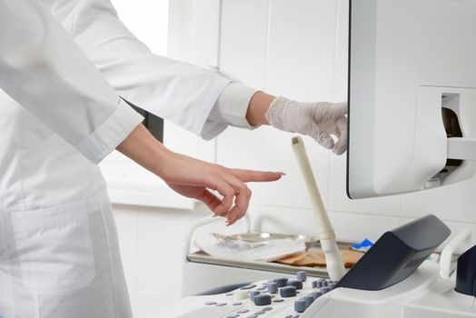 Gynecologist holding transvaginal ultrasound wand to exam woman