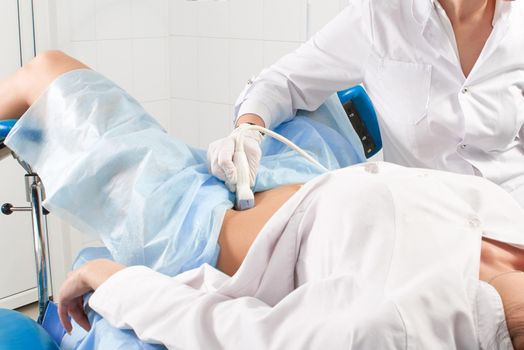 Cropped view of woman at gynecologist's doing ultrasound scan of the lower part