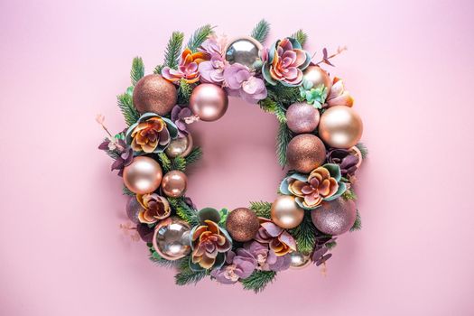 Beautiful unusual Christmas wreath hanging on pink wall