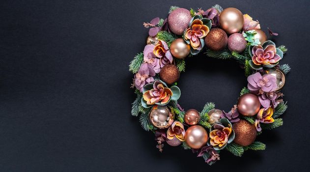 Beautiful unusual Christmas wreath hanging on pink wall