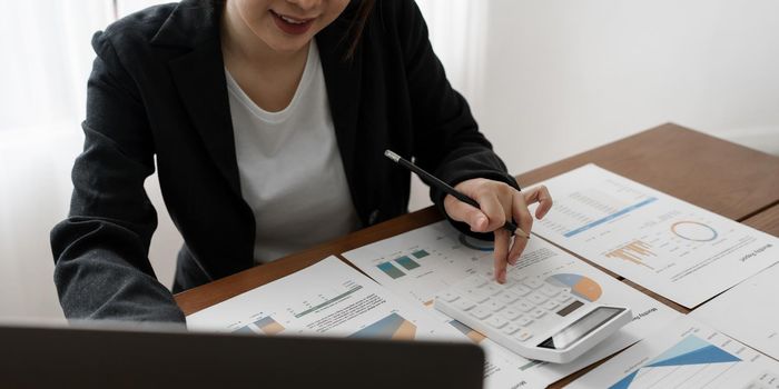 Modern business woman analysis financial and using calculator.