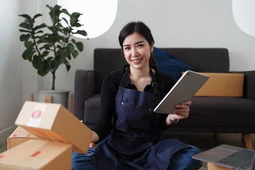 Asian SME business woman working at home office. online shopping concept.