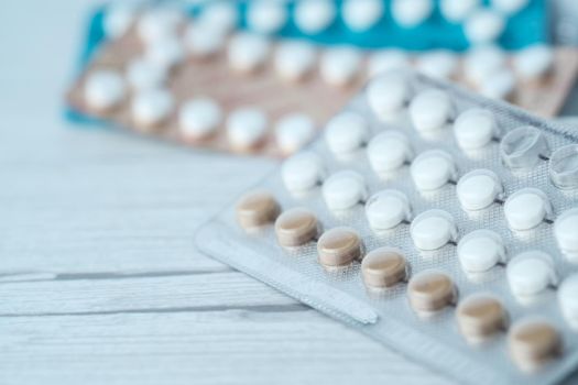 birth control pills on wooden background, close up .