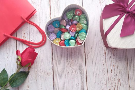 heart shape gift box with candy on table .