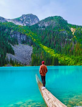 Joffre Lakes British Colombia Whistler Canada, colorful lake of Joffre lakes national park in Canada. Young men with hat visiting Joffre lake