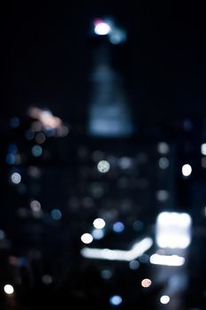 Blurry metropolitan district - night life, abstract background and modern dark tones concept. Big city comes alive at night