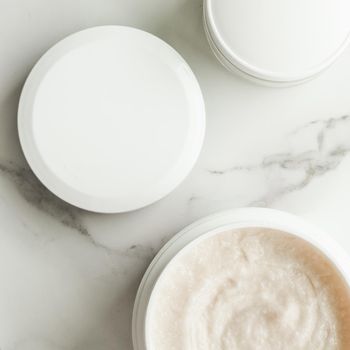 Scrub and exfoliating cream products on a marble, flatlay - skincare and body care, luxury spa and clean cosmetic concept. Health and beauty of your skin