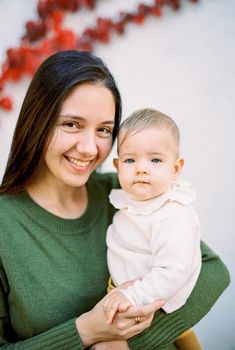 Smiling mother with a baby in her arms. Portrait. High quality photo