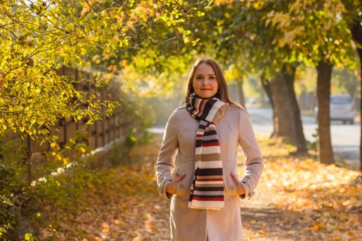 Happy woman wearing warm clothes in the autumn park