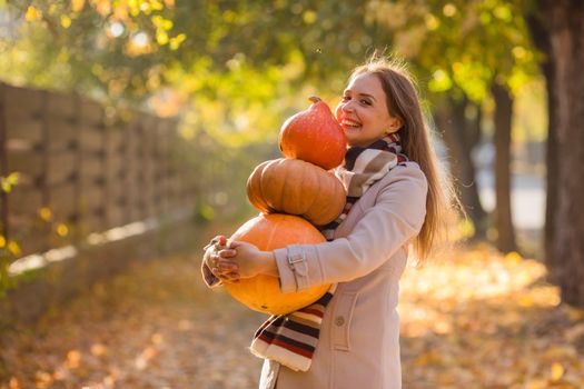 Portrait of happy smile woman with pumpkins in hand. Cozy autumn vibes Halloween, Thanksgiving day.