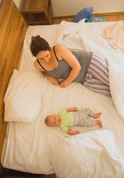 Mother and newborn baby sleep in the bed together