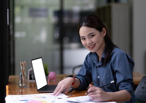 Shot of a asian young business Female working on laptop computer in her workstation.Portrait of Business people employee freelance online marketing e-commerce telemarketing concept..