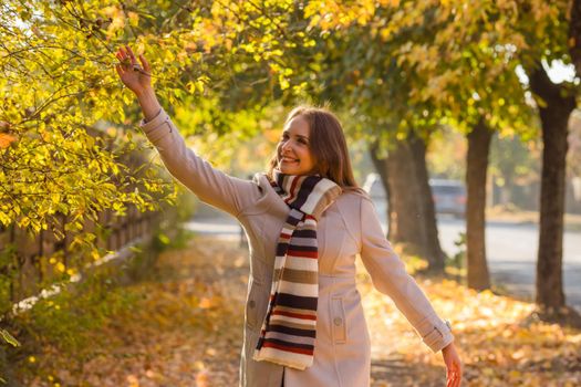 Happy woman wearing warm clothes in the autumn park