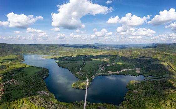 Spectacular aerial panorama from a drone to a lake and a road between hills. Yovkovtsi, Bulgaria