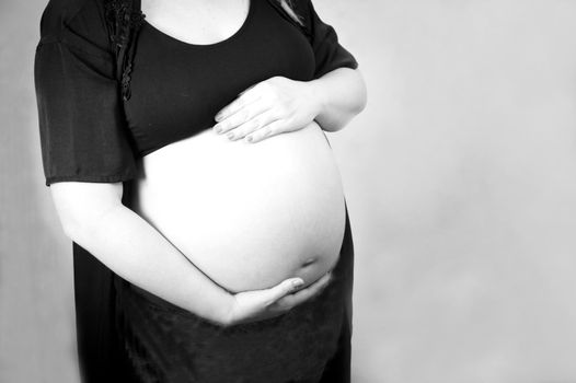 Eight month pregnant woman with bare belly. Happy emotion