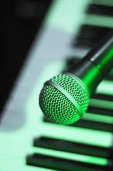 Microphone over piano keys in dim light. No people