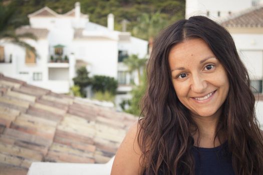 Portrait of youthful woman on mountain background. Smiling.