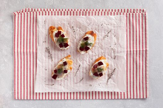 smoked hering, beet root and soft cheese toasts, top view