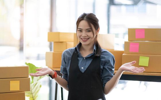 Portrait of Asian young woman SME working with a box at home the workplace.start-up small business owner, small business entrepreneur SME or freelance business online and delivery concept..
