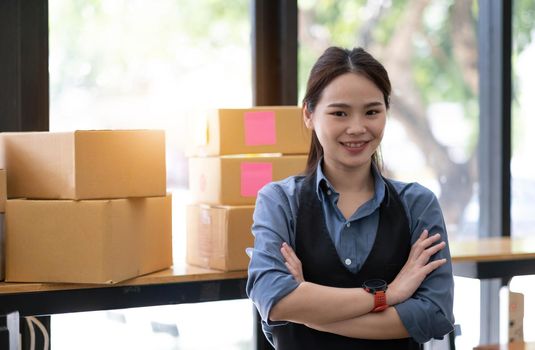 Portrait of Asian young woman SME working with a box at home the workplace.start-up small business owner, small business entrepreneur SME or freelance business online and delivery concept..